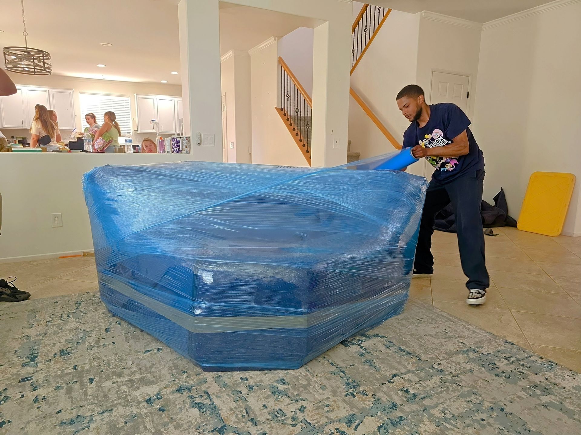A living room with two couches wrapped in plastic.