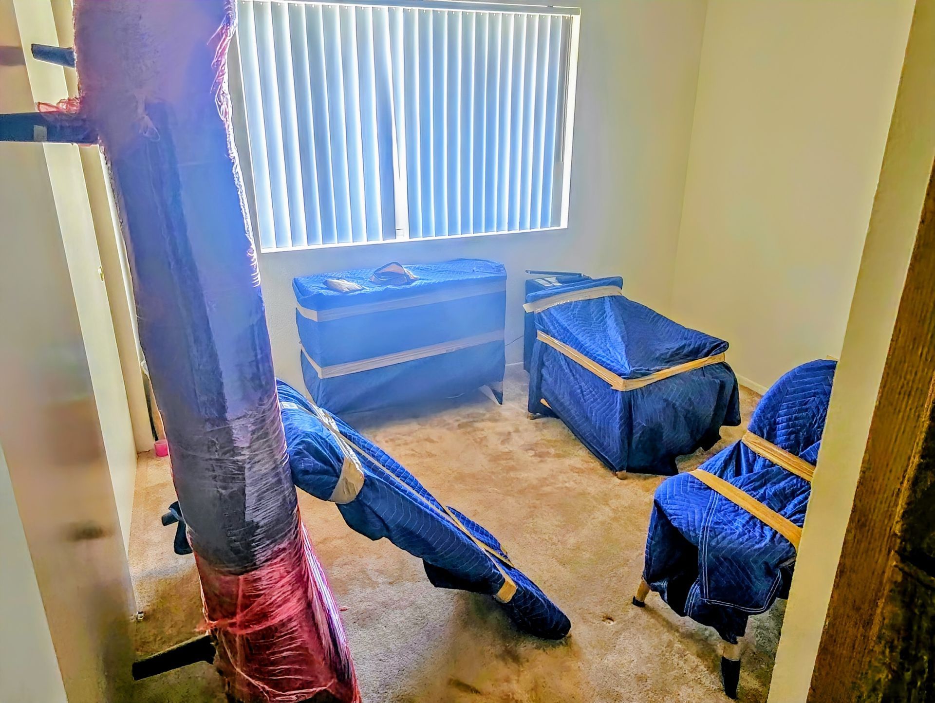 Two movers loading cardboard boxes into a moving truck in front of a house.