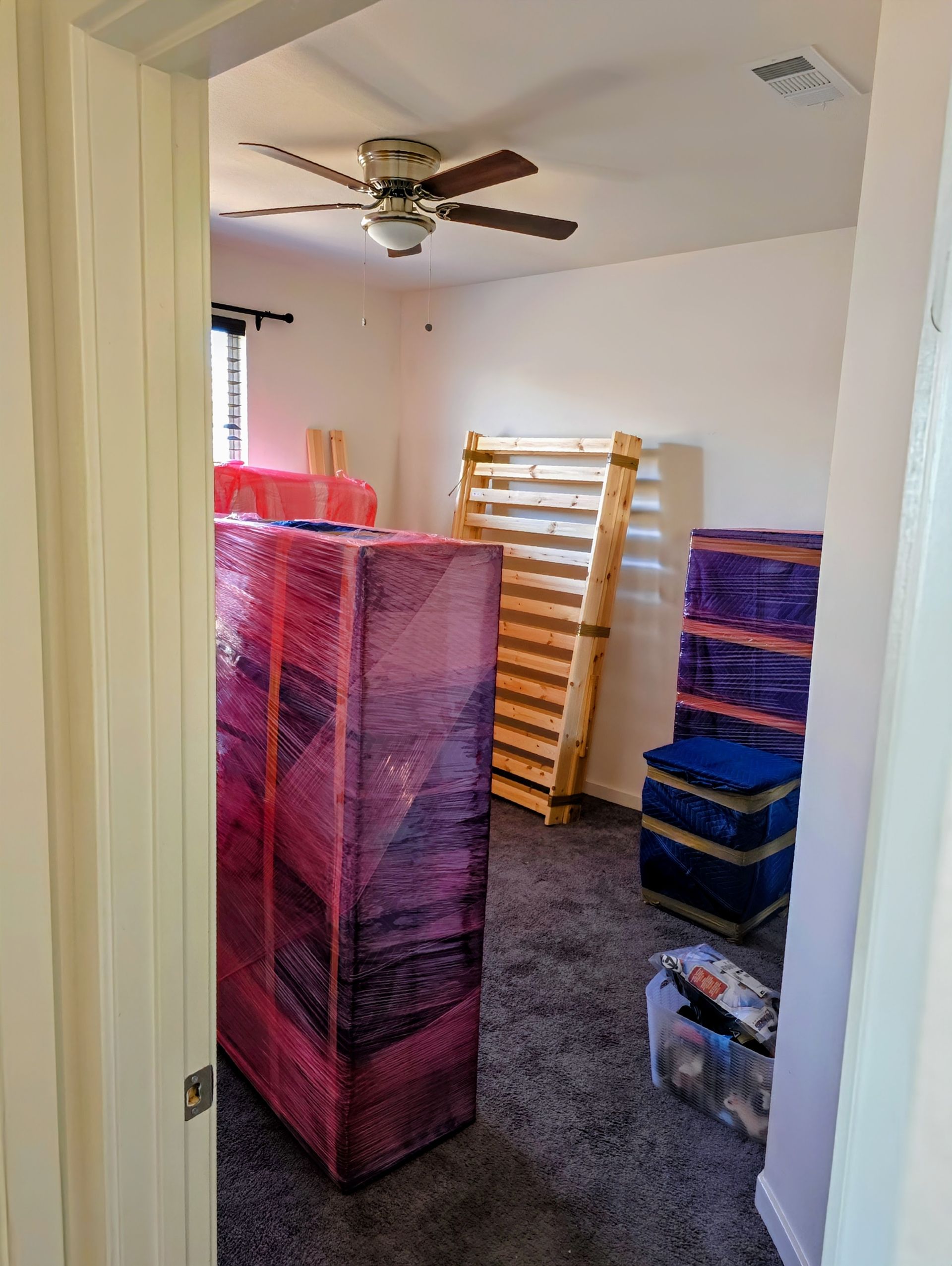 Cargo truck open, loaded with cardboard boxes and a white shelving unit.