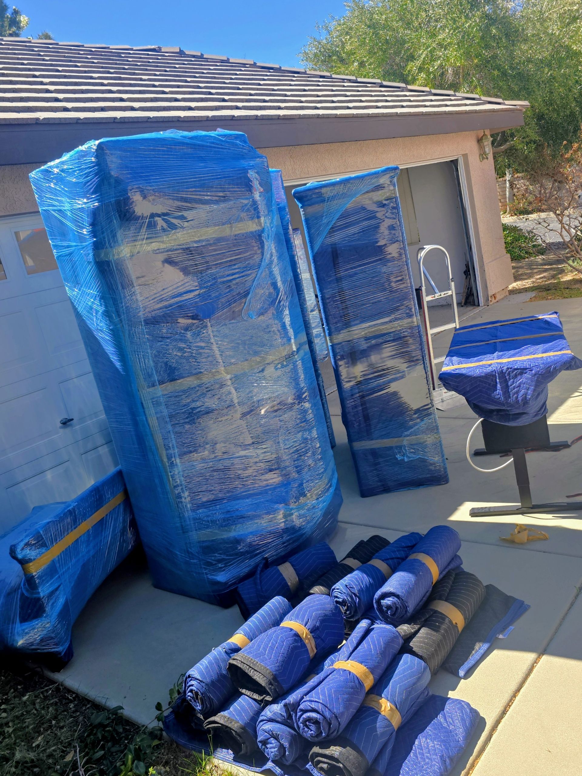 The back of a moving truck filled with boxes wrapped in plastic