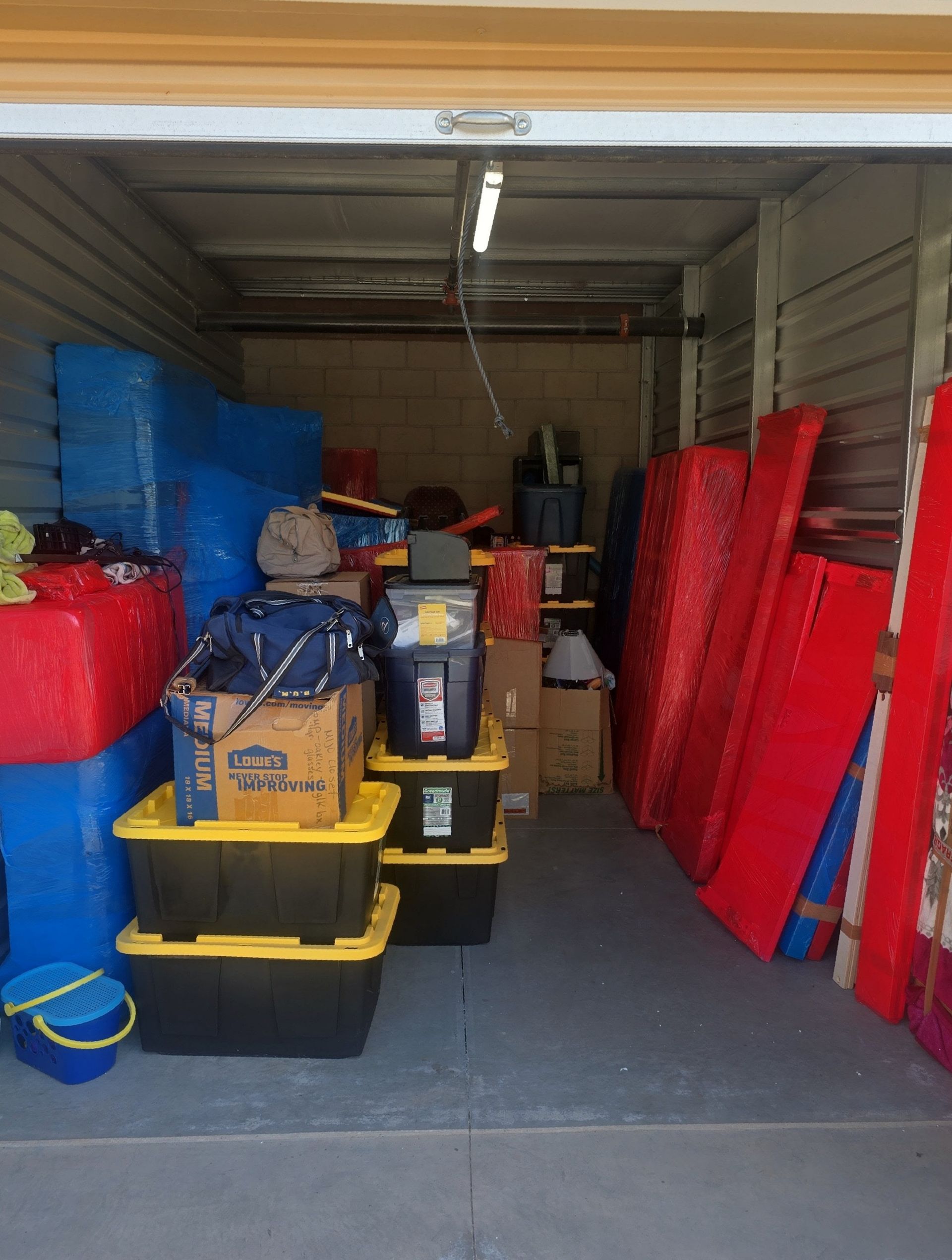 A man is standing in the back of a truck filled with boxes.