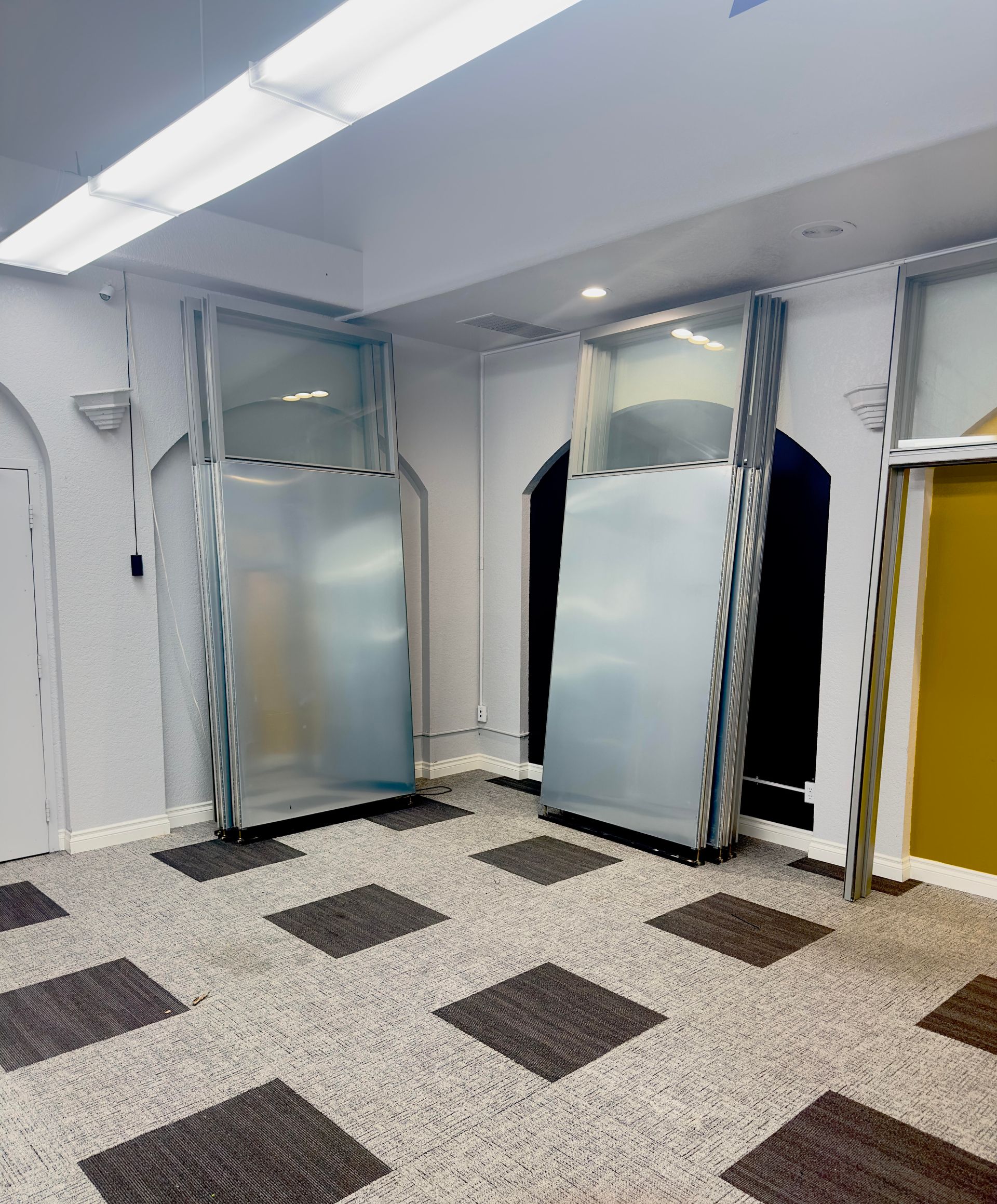 A room with a lot of doors and a carpeted floor