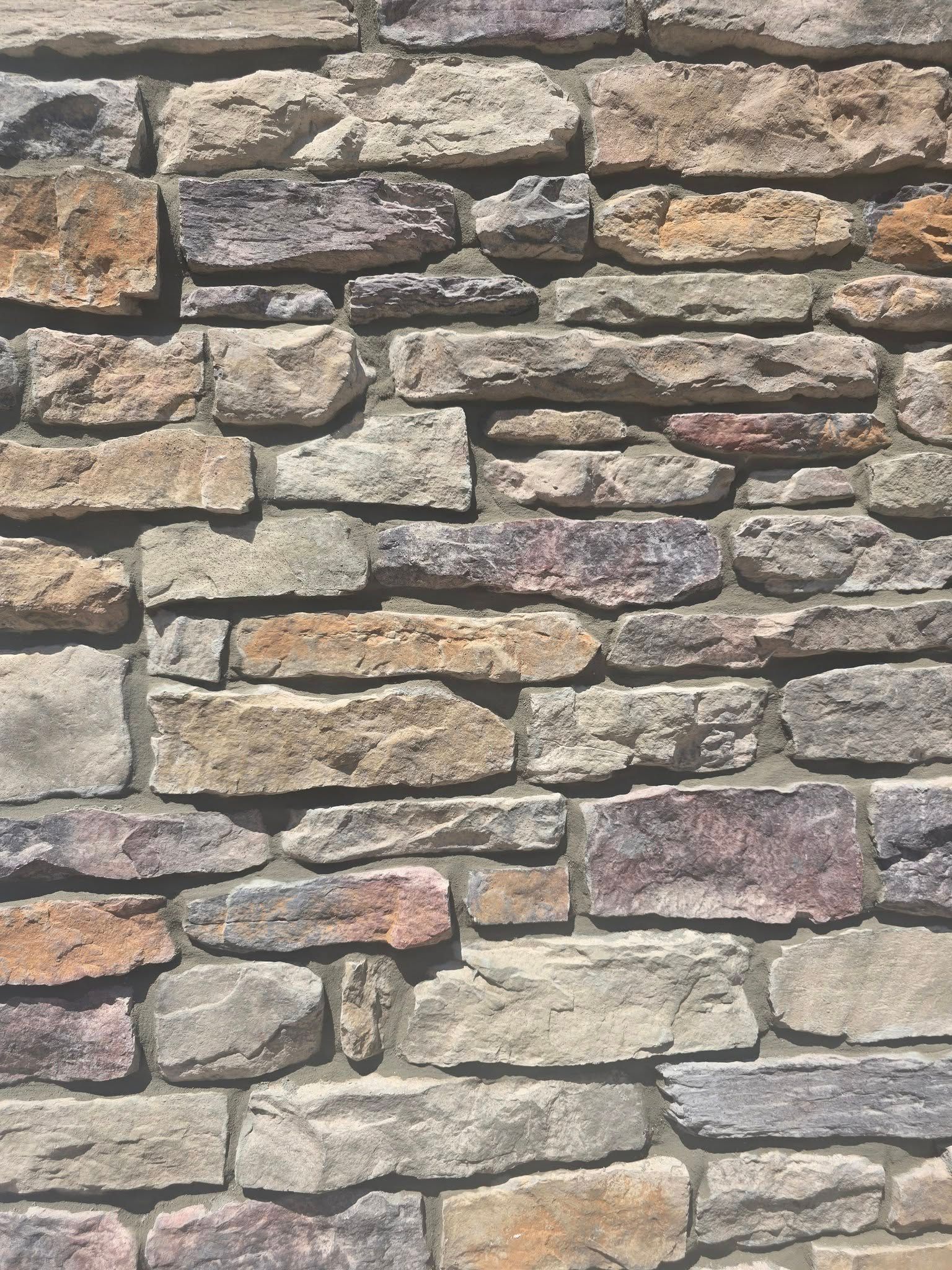 A close up of a stone wall made of different types of rocks.
