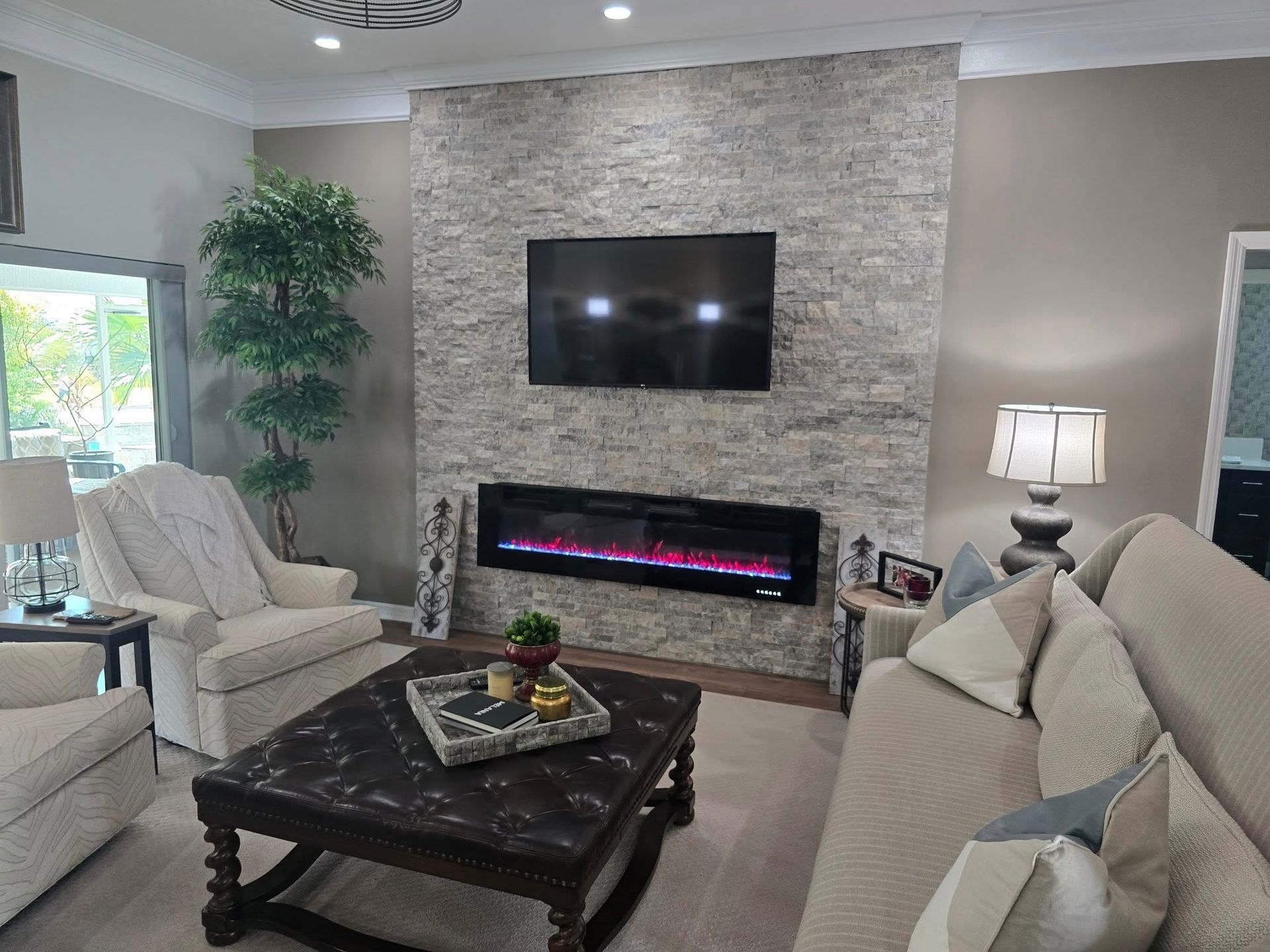 A living room with a fireplace and a flat screen tv on the wall.