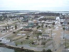 An aerial view of a flooded city with a lot of buildings and trees.
