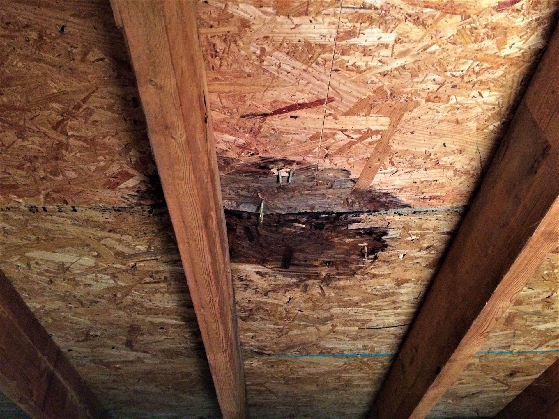 A close up of a wooden ceiling with a hole in it.