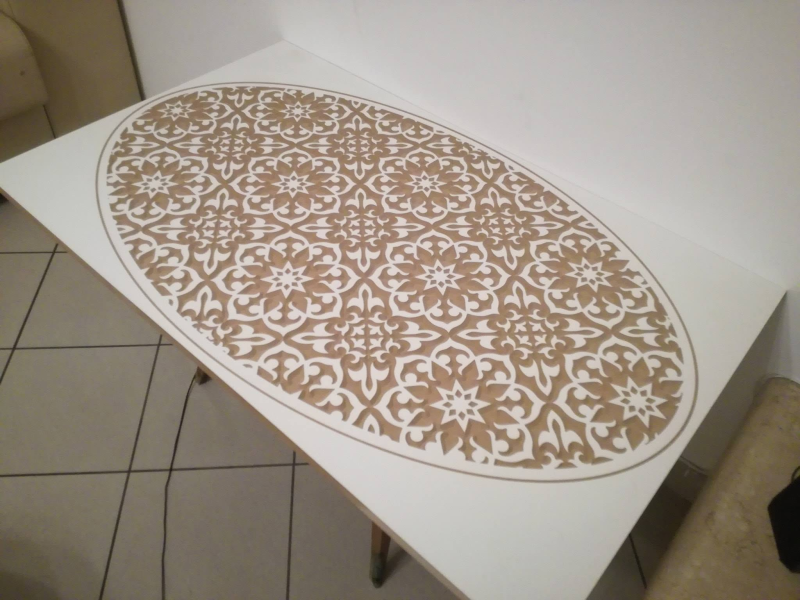 Tovaglietta ovale con motivo floreale su un tavolo bianco in una stanza piastrellata.