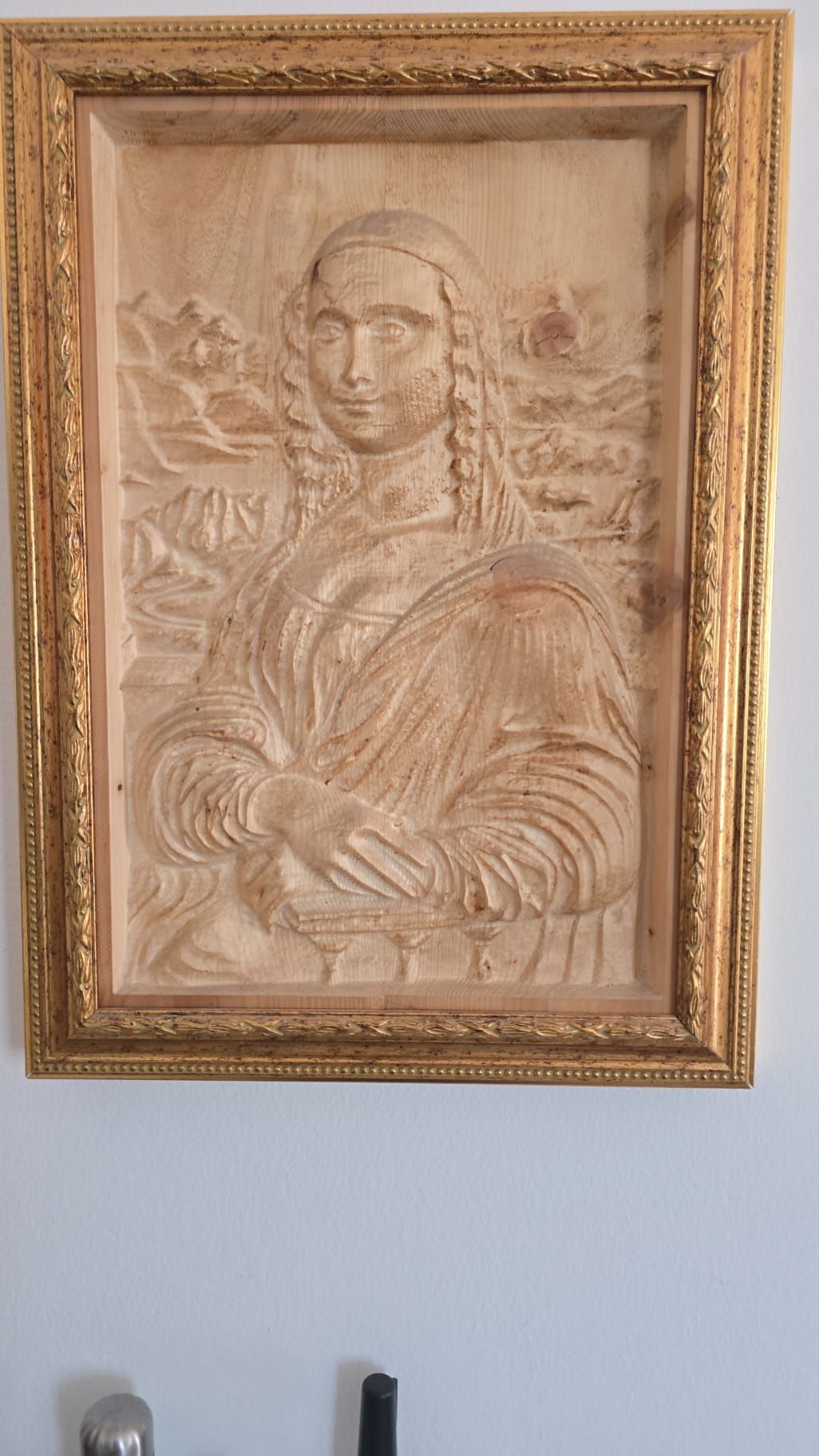 Ritratto incorniciato in seppia di una figura ammantata appeso a una parete azzurra