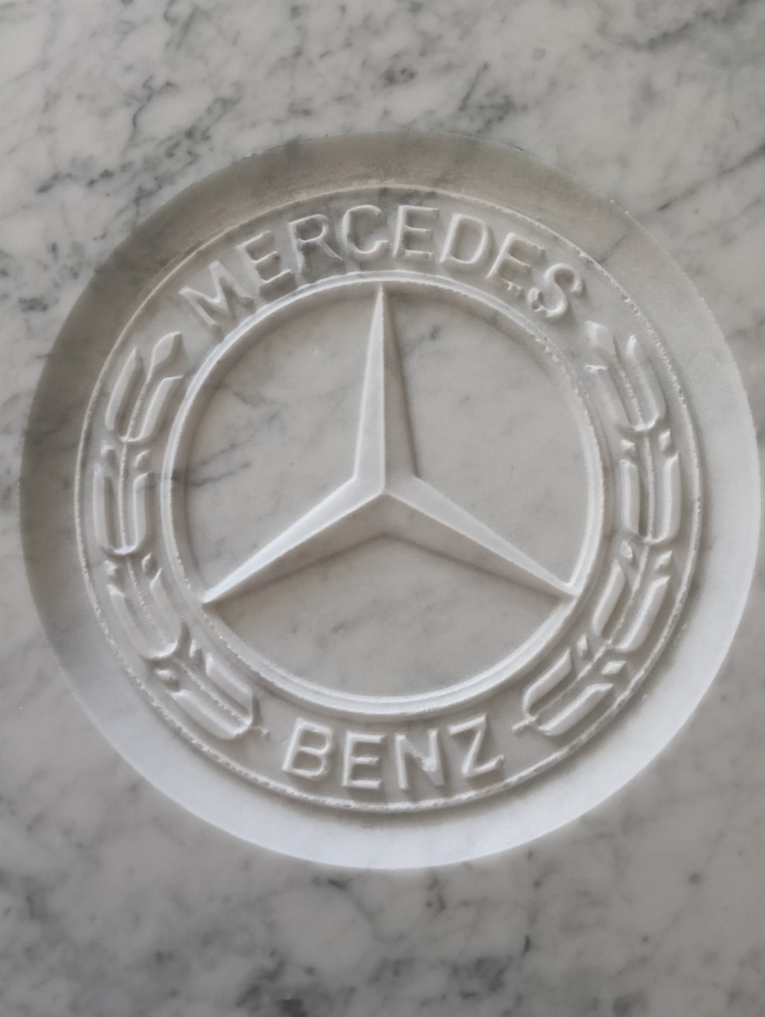 Logo Mercedes-Benz su una superficie di marmo bianco