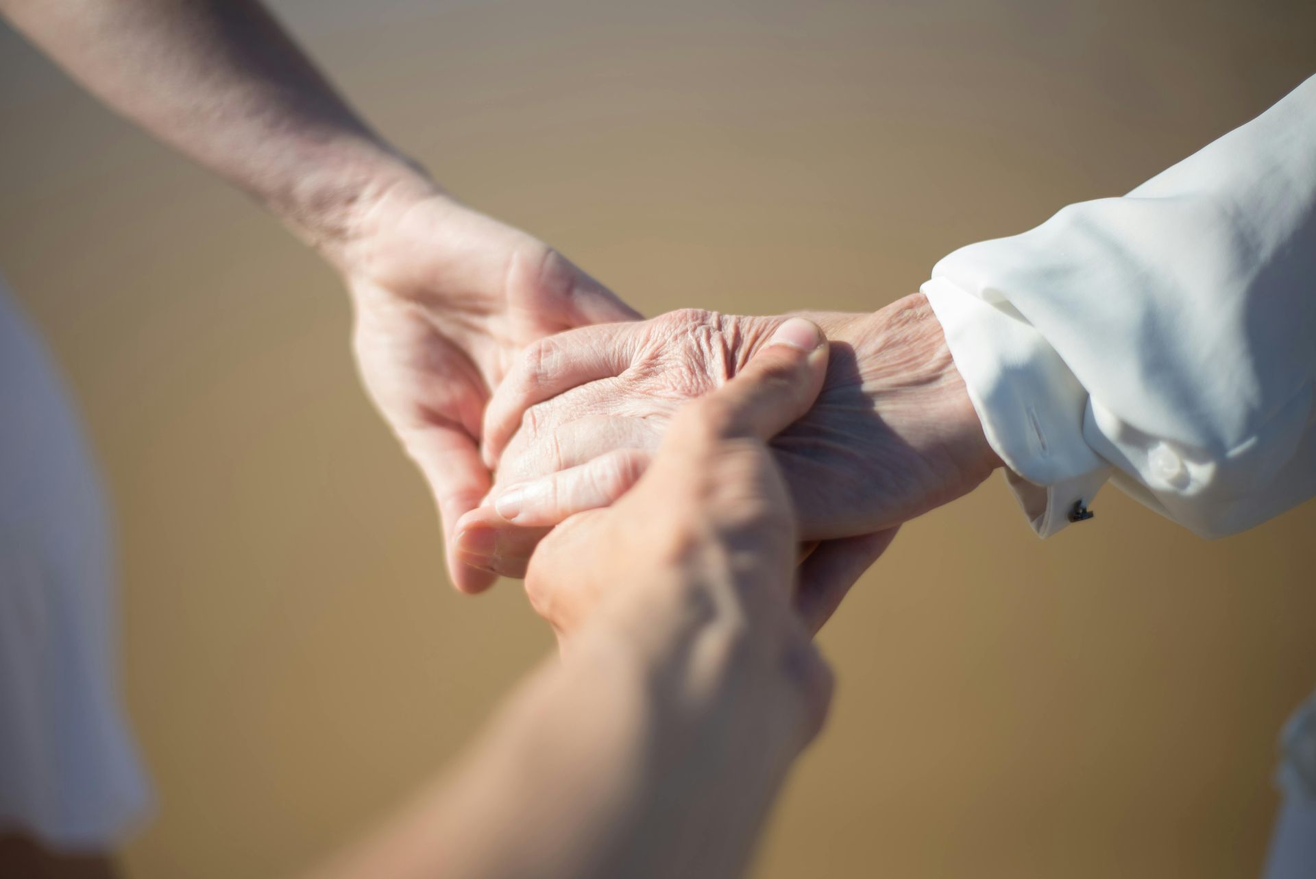 Hands clasped together, possibly offering comfort or support.