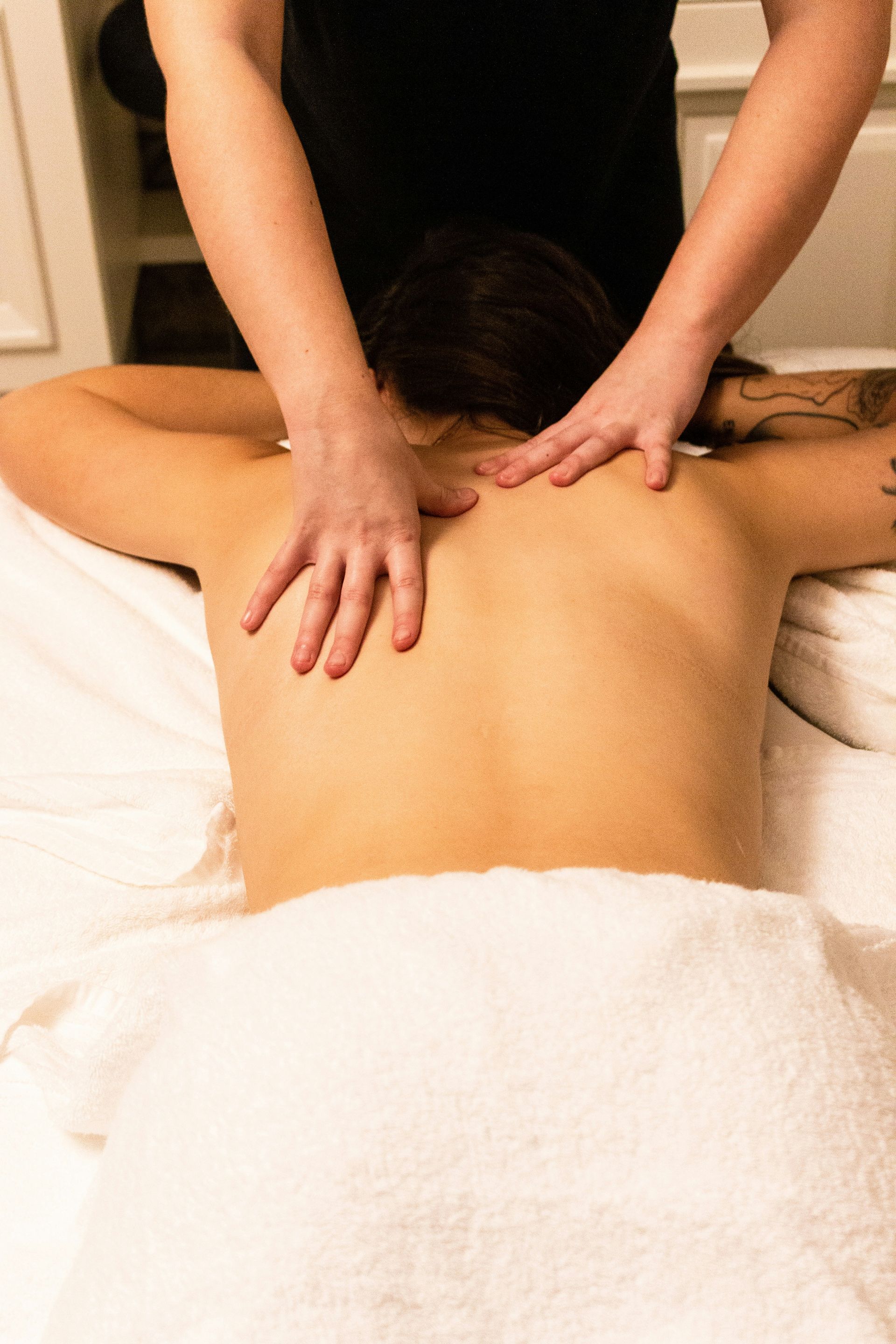 A woman is getting a massage on her back at a spa.