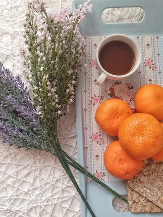 A tray with oranges and a cup of tea on it