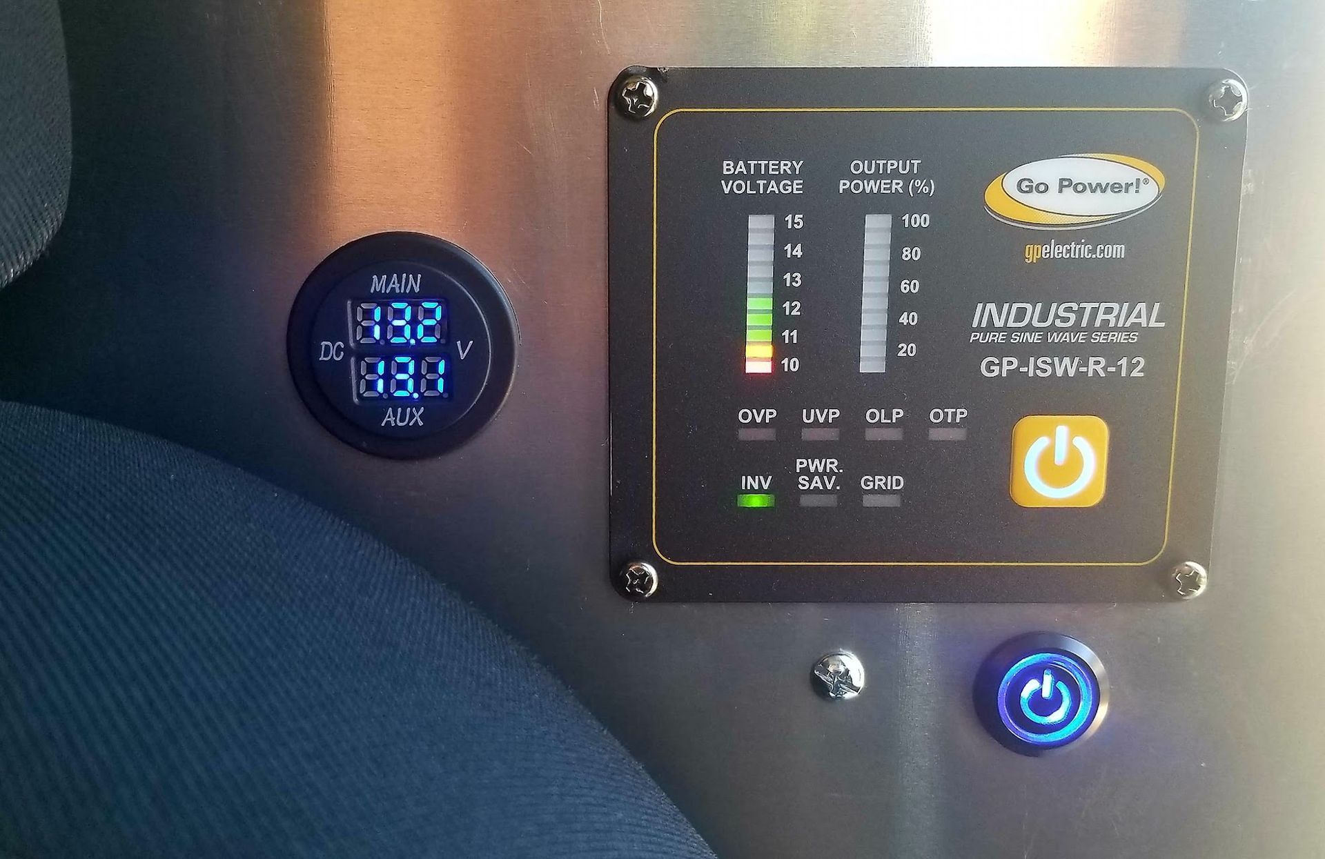 Car dashboard panel with a digital gauge and illuminated power buttons on a black console