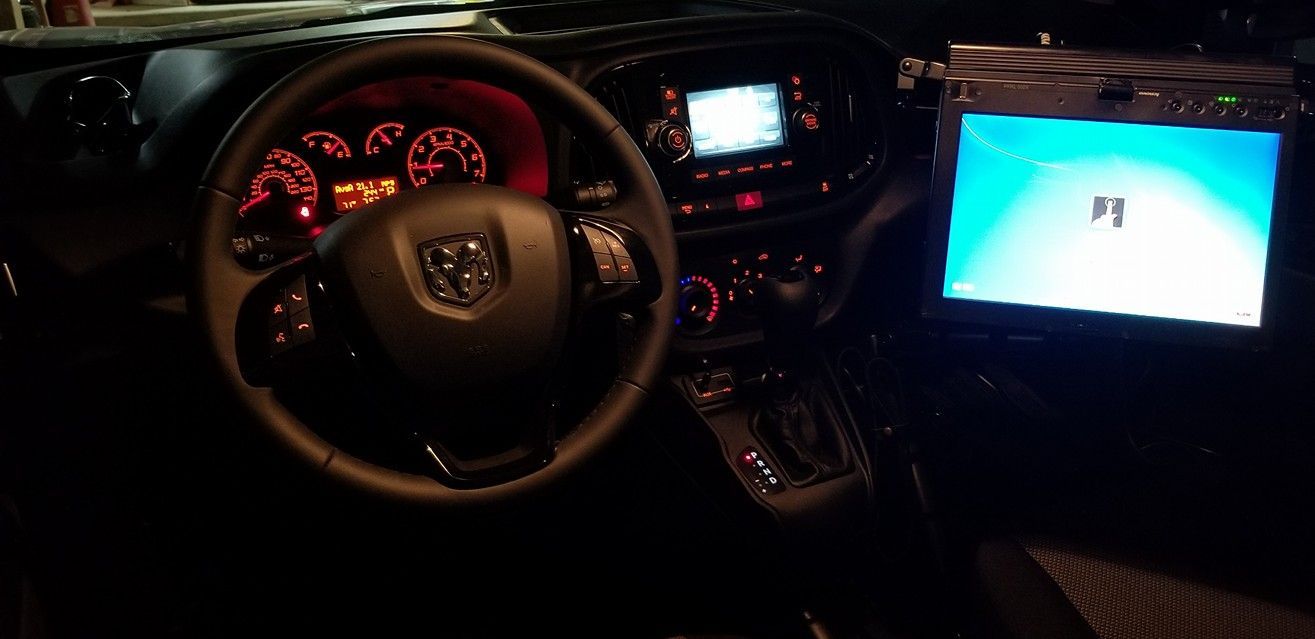 Car dashboard at night with illuminated gauges and a center screen glowing blue.