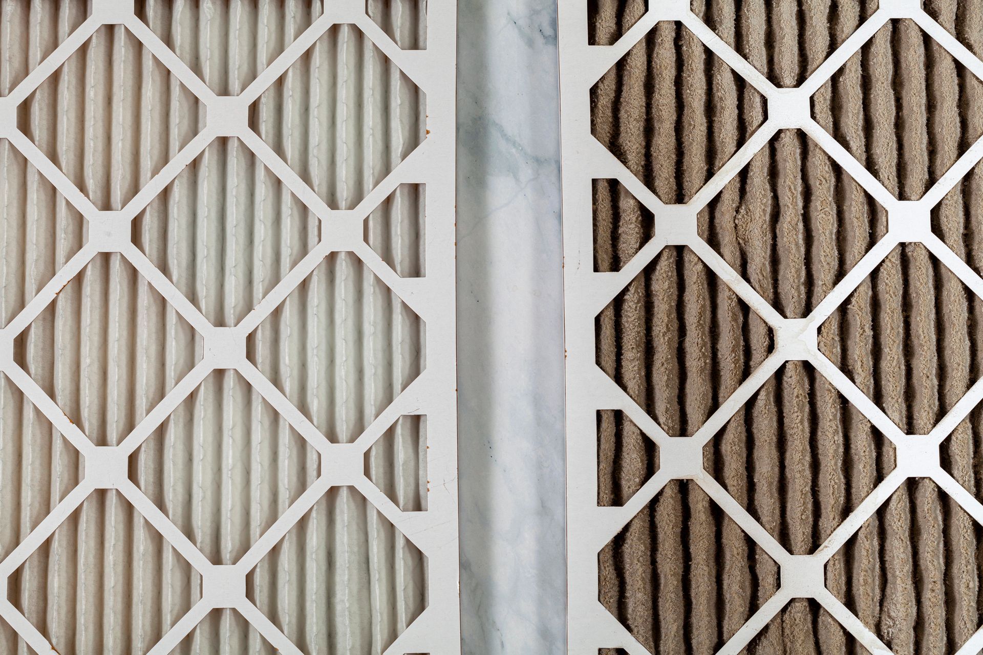Two HVAC filters; one clean and white, the other dirty and brown.