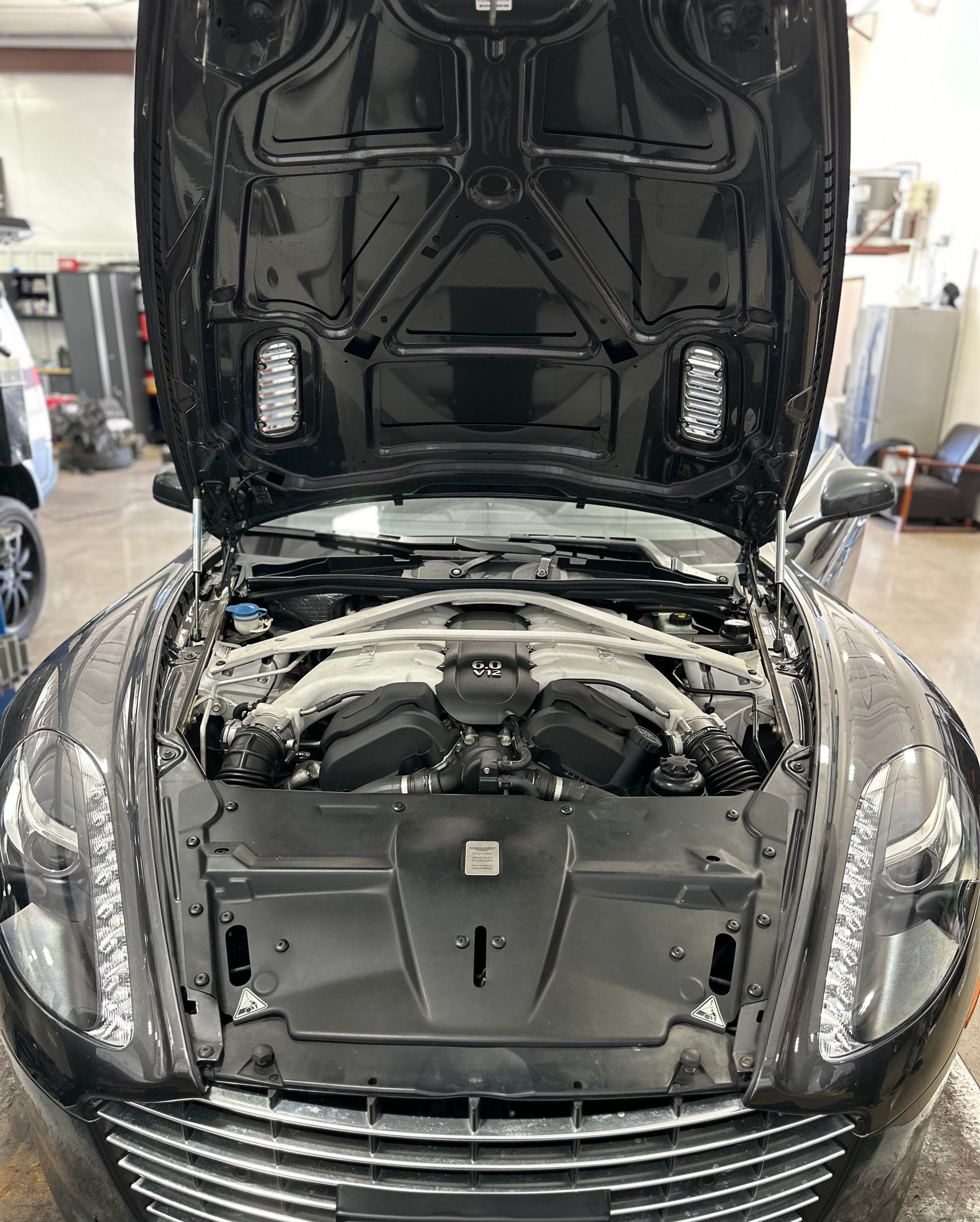 Black Aston Martin sports car with the hood open | Peak European