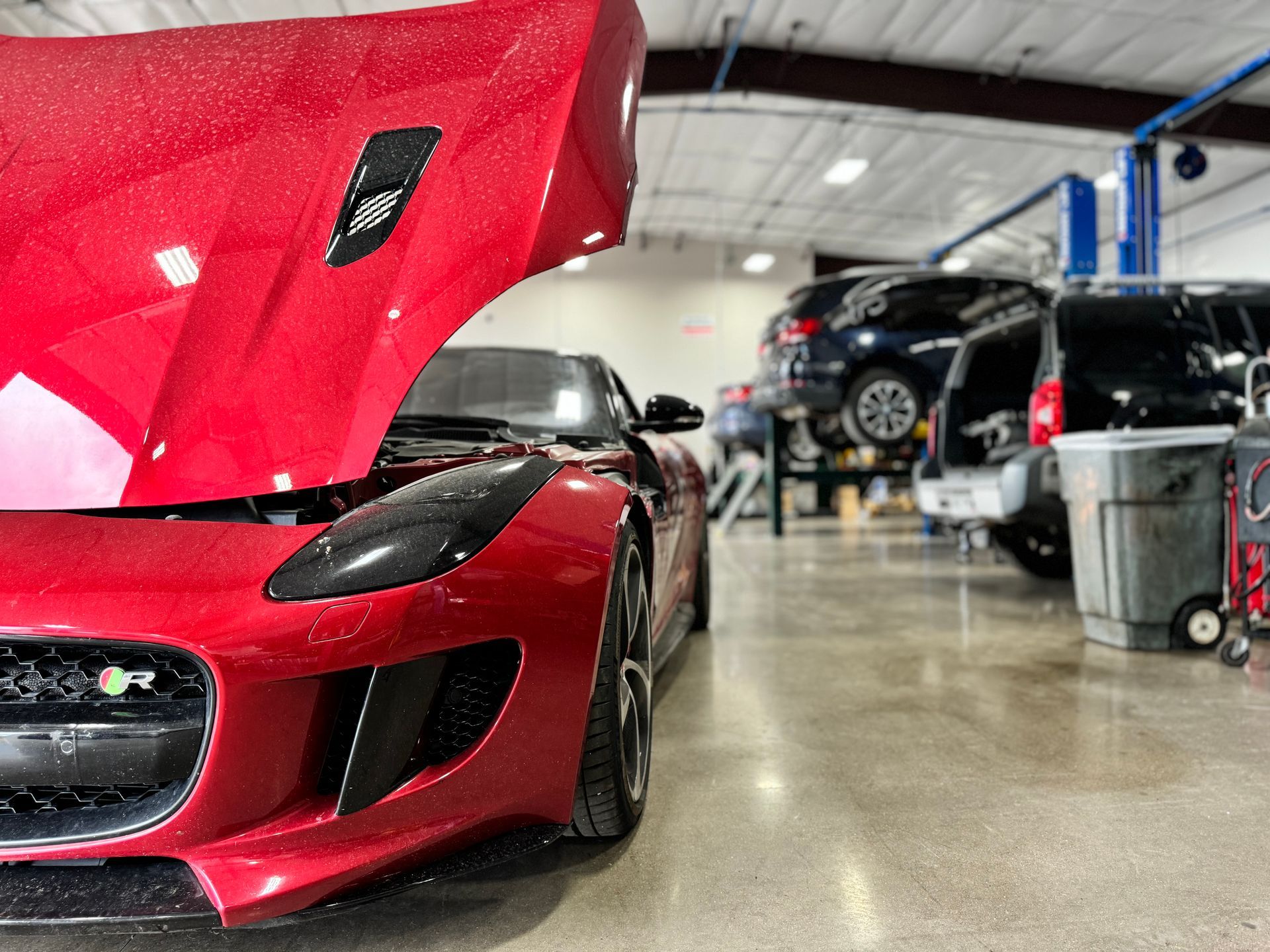 Red Jaguar sports car with its hood up | Peak European