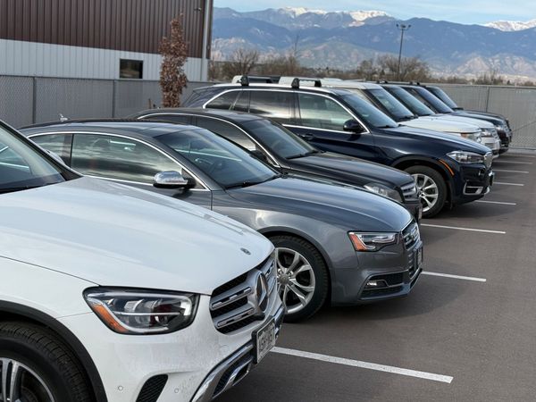 A row of luxury cars parked in a lot | Peak European