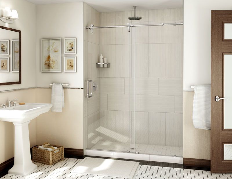 Bathroom with white tiles, pedestal sink, glass shower with sliding door, and dark wood door frame.