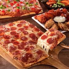 Pizza and chicken wings on wooden boards, a casual dining scene.
