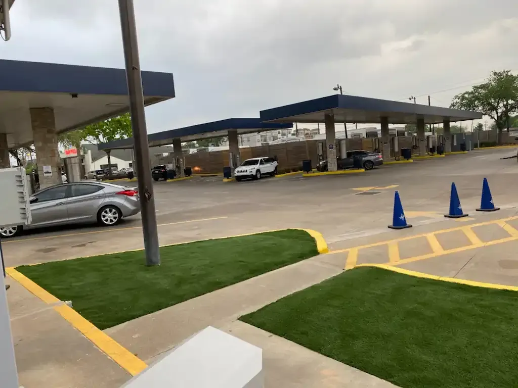 A car is parked in a parking lot at a gas station