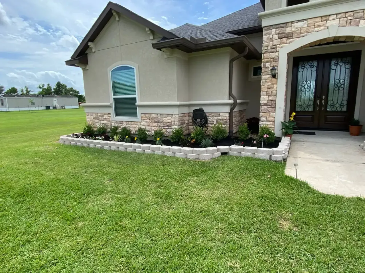 A house with a lush green lawn in front of it.