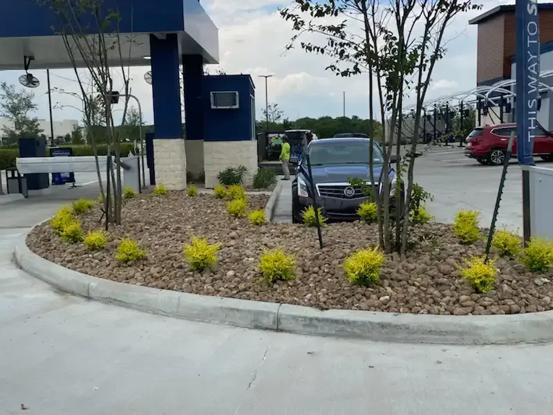 A car is parked in a parking lot next to a sign that says this way