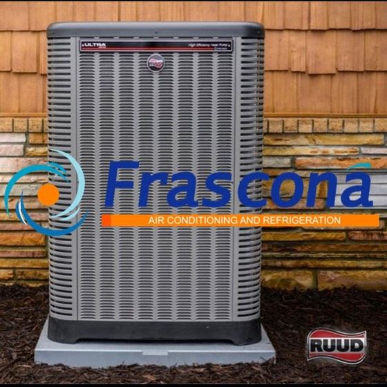Outdoor air conditioning unit against a red brick wall.