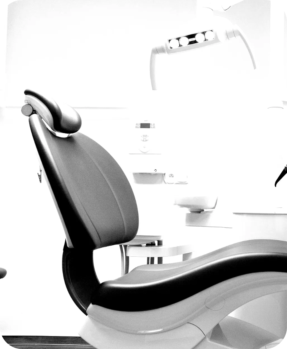 Dentist chair in a bright dental clinic, with an overhead examination light nearby