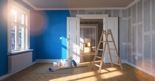 A picture of a room with half painted blue and half not painted yet.