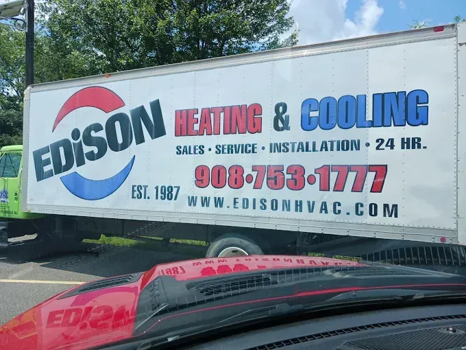 Edison Heating & Cooling truck with large service sign and phone number parked outdoors