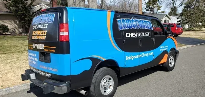 Bright blue-and-black Chevrolet service van parked on a residential street