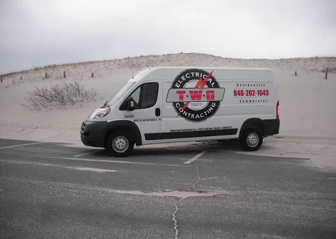 White service van with T.W.B. Electric logo parked on a snowy roadside