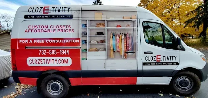 White delivery van with CLOZETIVITY branding, red accents, and a closet organization ad parked outdoors.