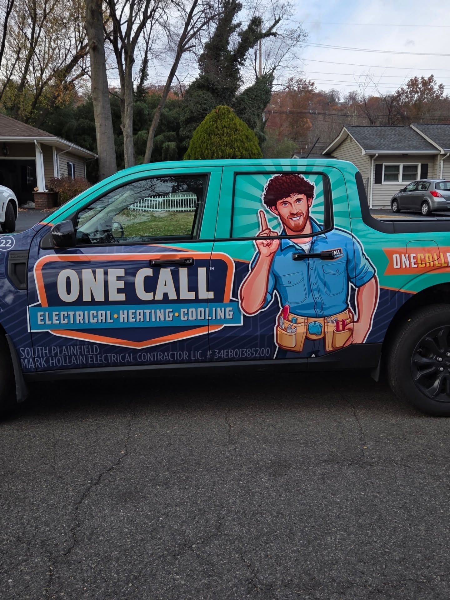 Branded van with “One Call” electrician-heating-cooling ad, featuring a cartoon tradesman on the side.