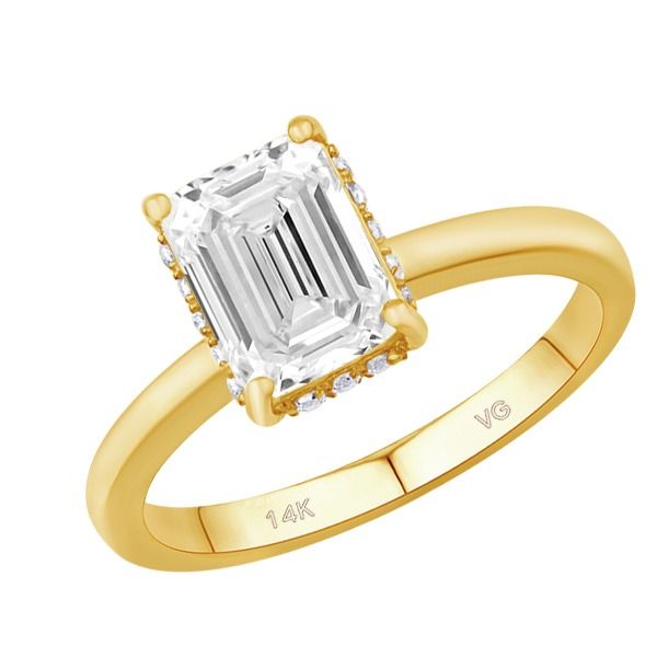 A yellow gold ring with an emerald cut diamond