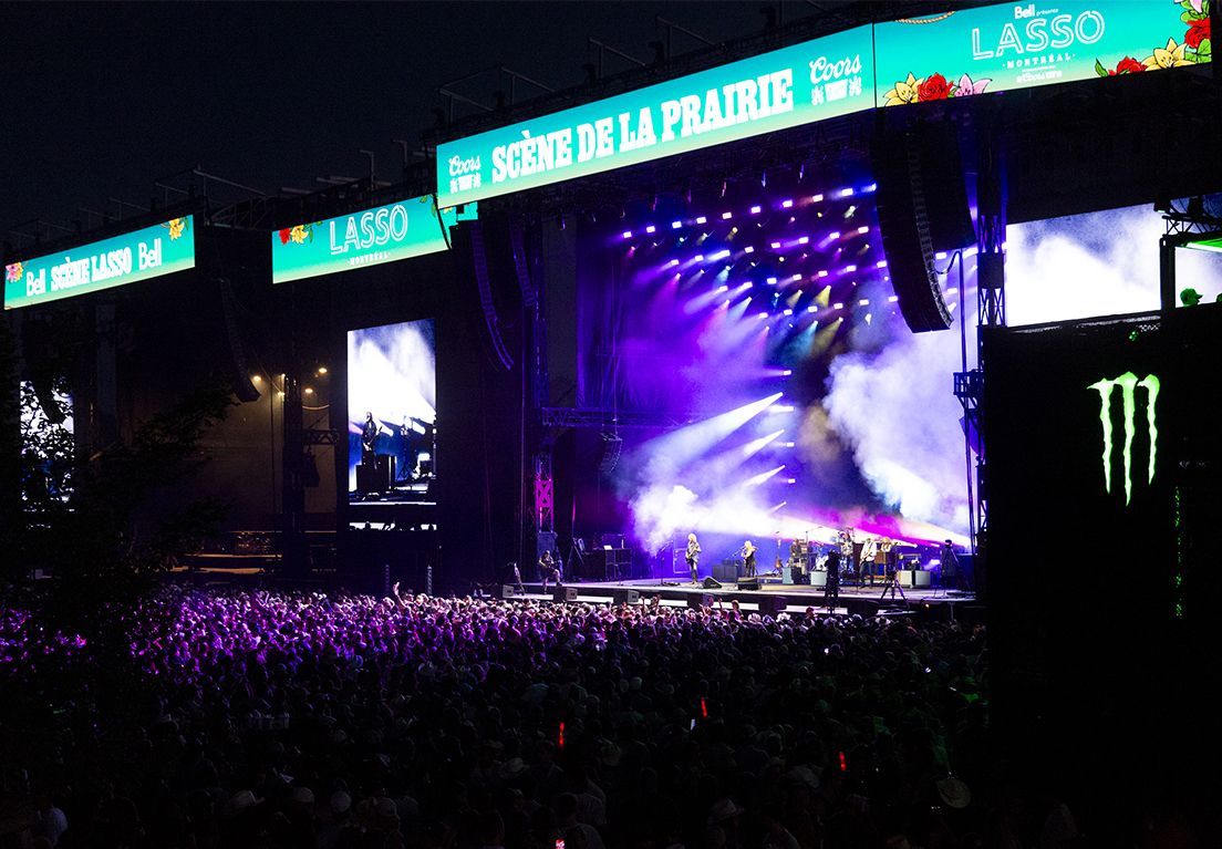 Festival crowd standing and cheering in front of the LASSO Montréal 2025 main stage 