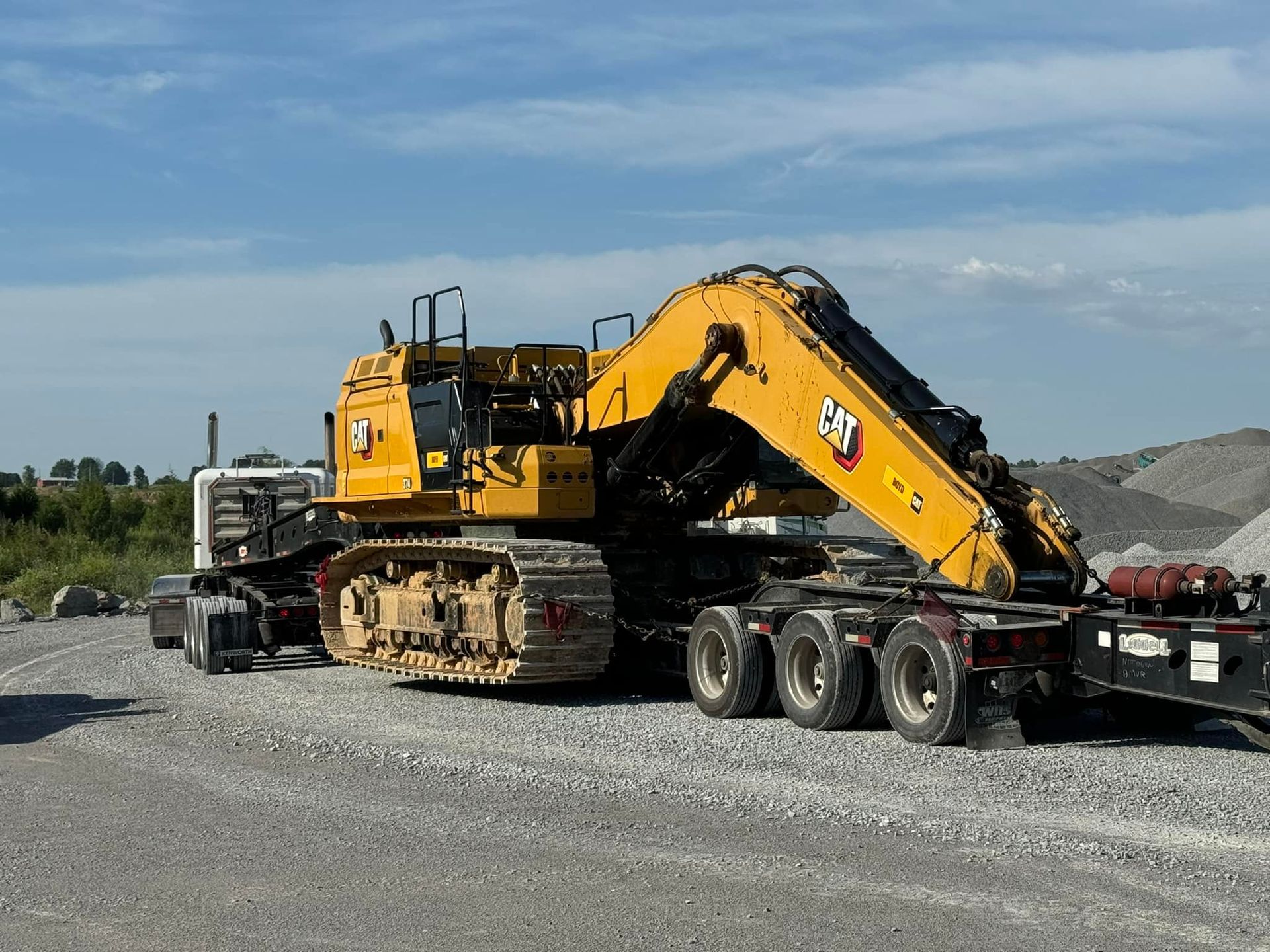 A large yellow excavator is sitting on top of a trailer.