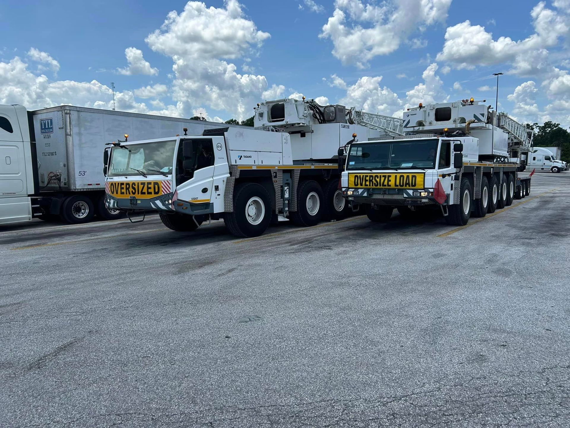 Two large trucks are parked next to each other in a parking lot.