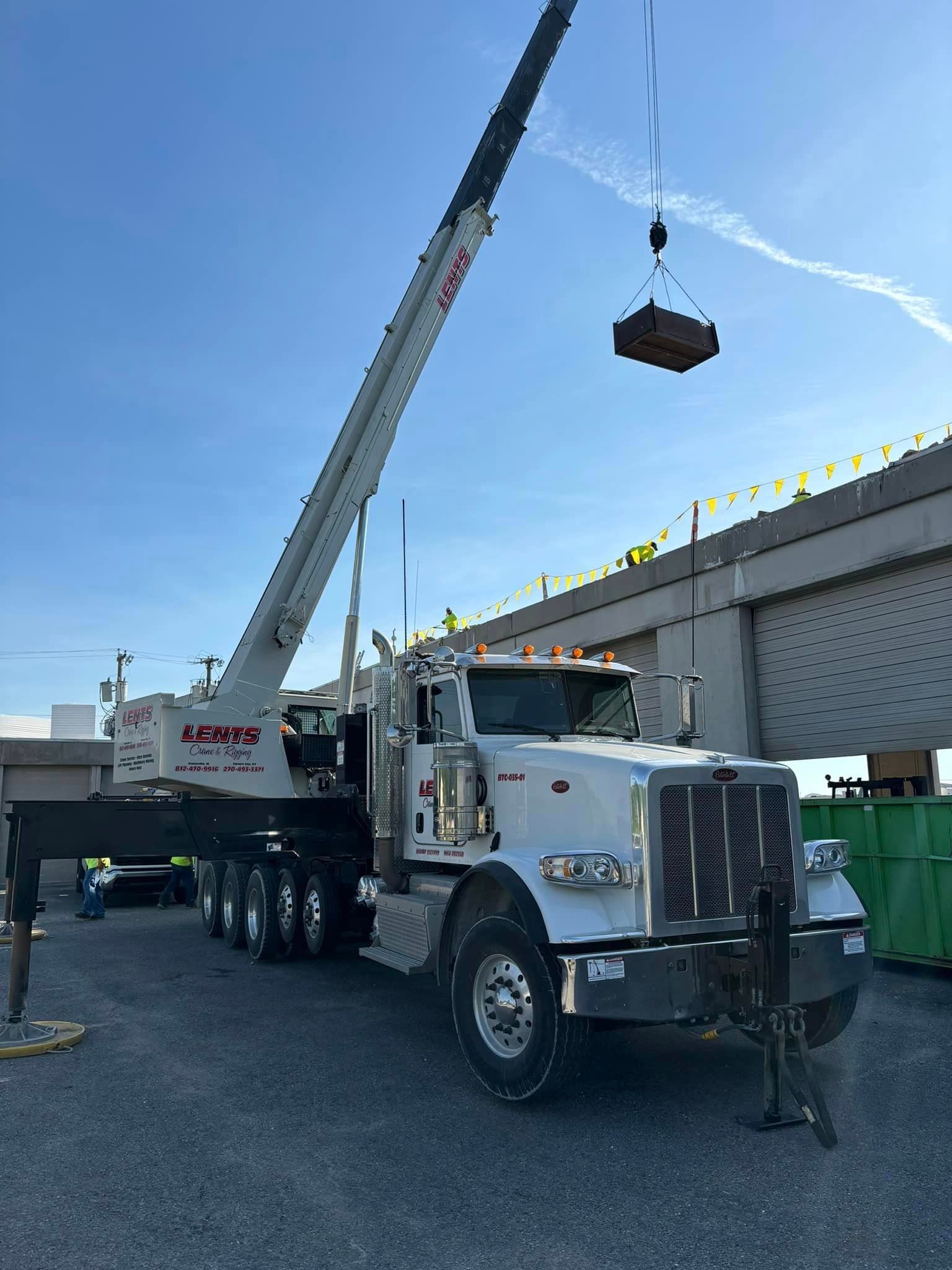 A large white truck with a crane attached to it.