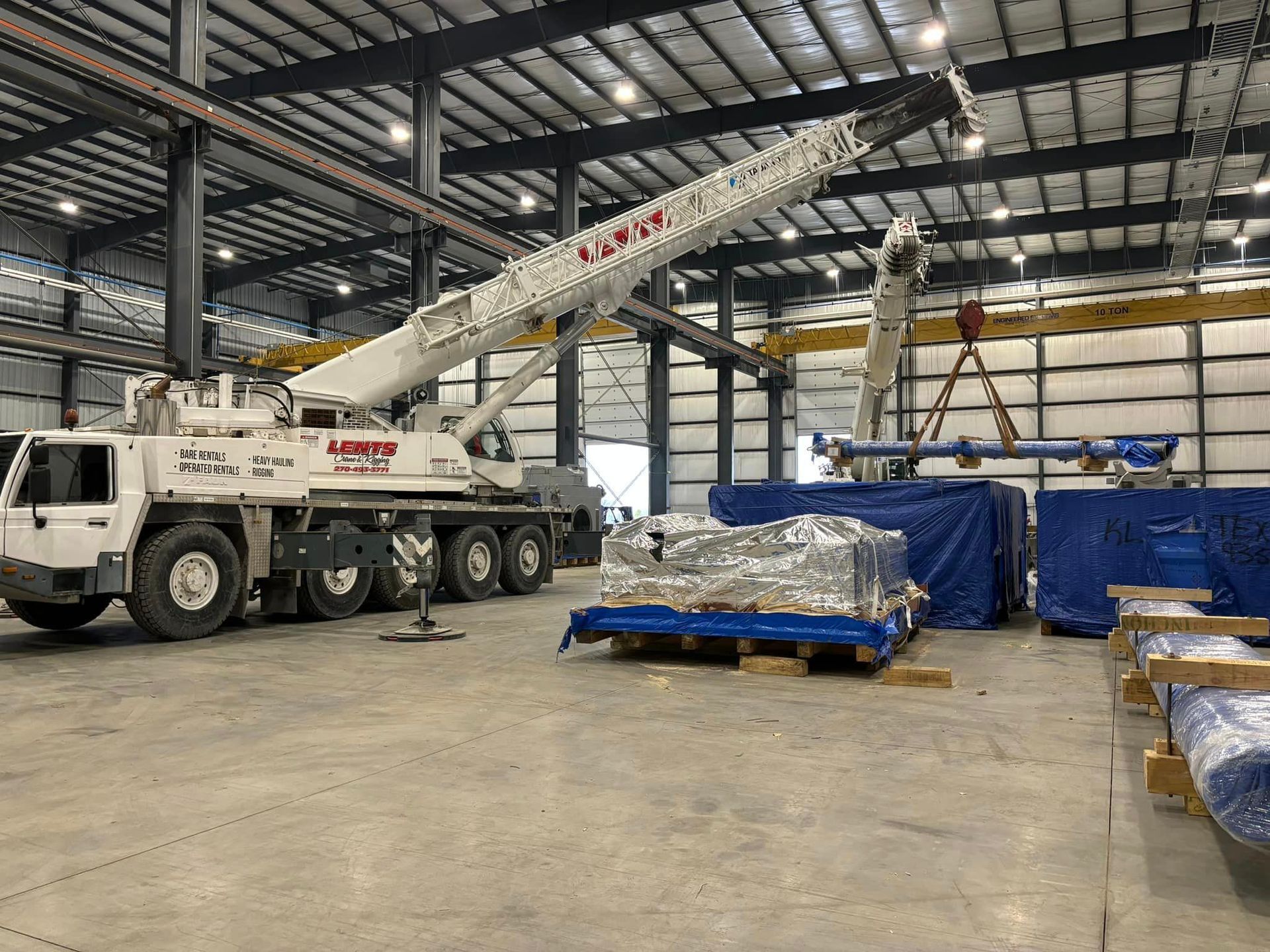 A large crane is parked in a large warehouse.