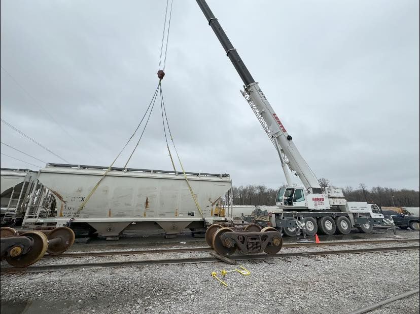A crane is lifting a train car on a cloudy day