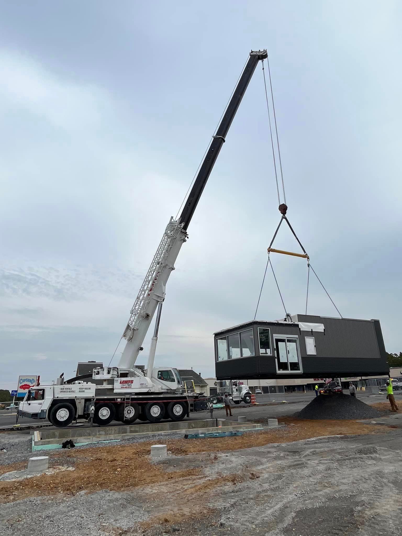 A large crane is lifting a building on a construction site.