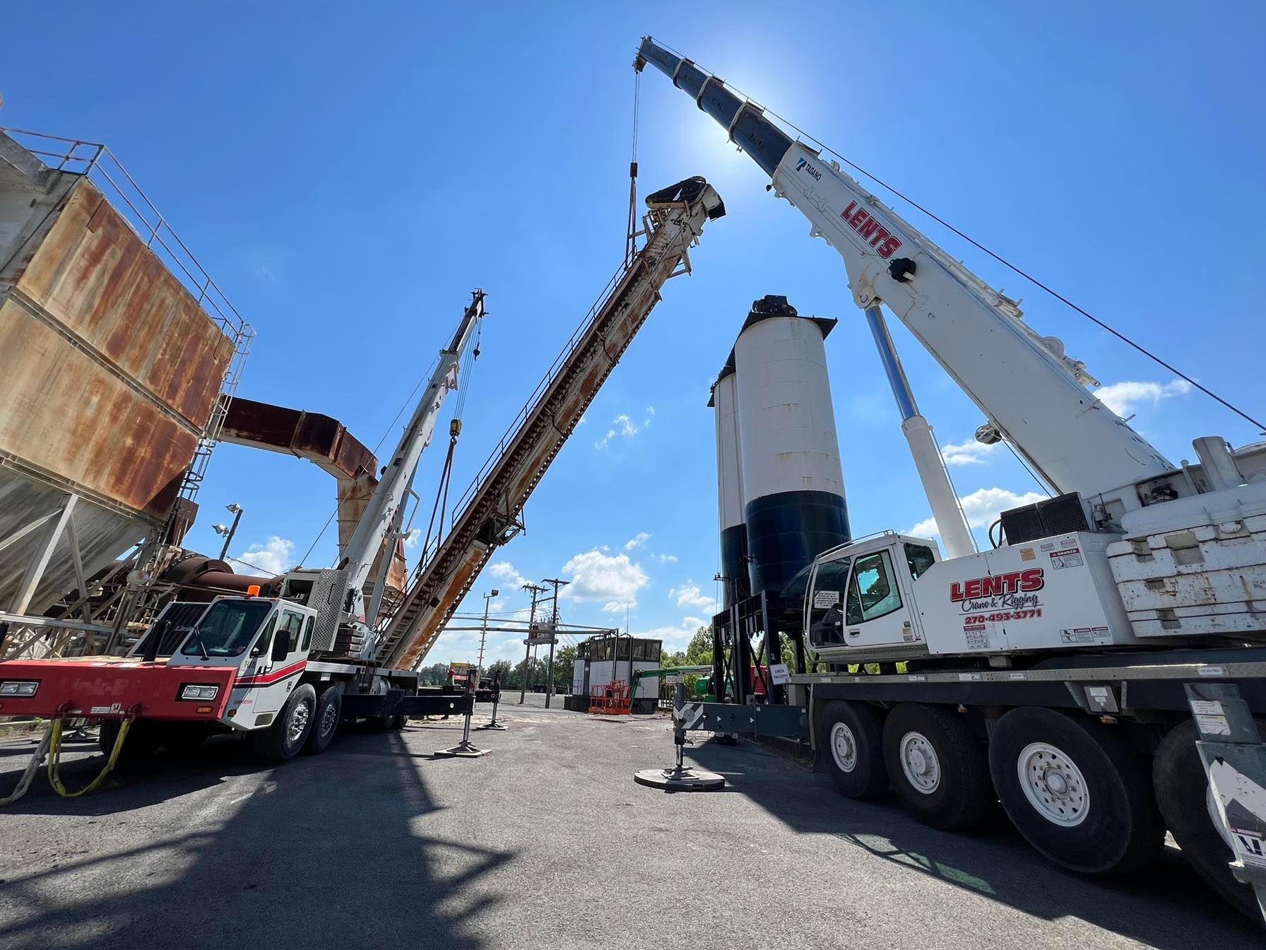 A large crane is being used to lift a large concrete container.