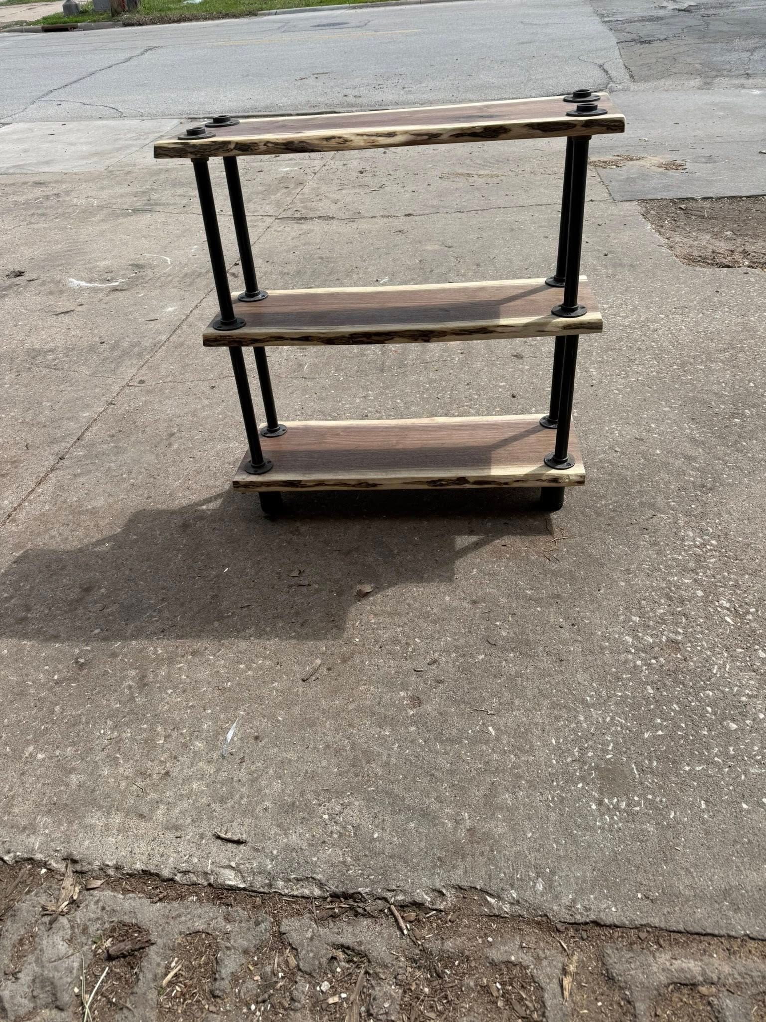 Damaged wooden shelf standing on a concrete sidewalk outdoors