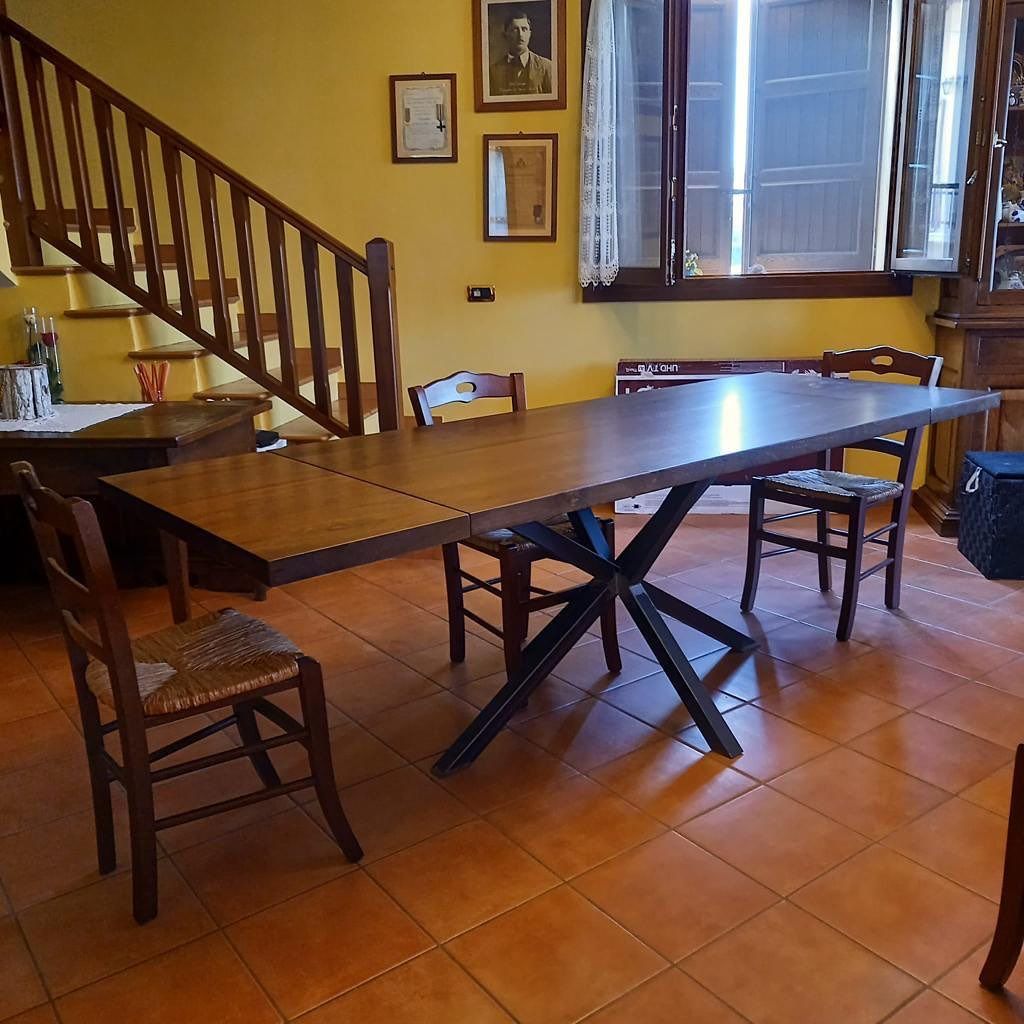 Cucina con mobili verdi, isola grigia ed elettrodomestici in acciaio inossidabile.