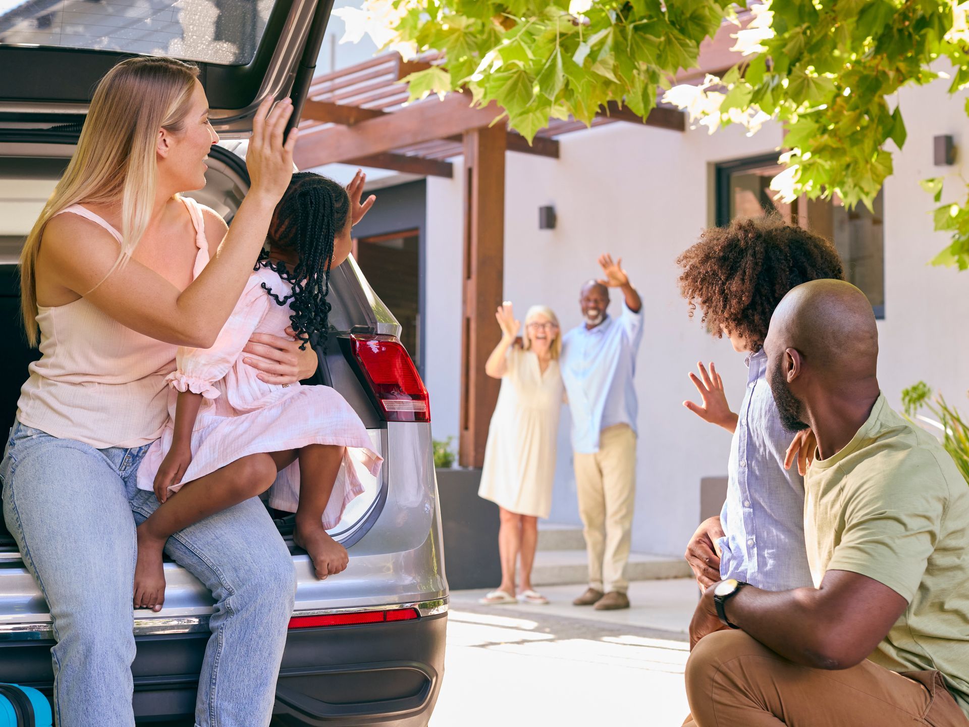 A family is moving into a new home carrying boxes.