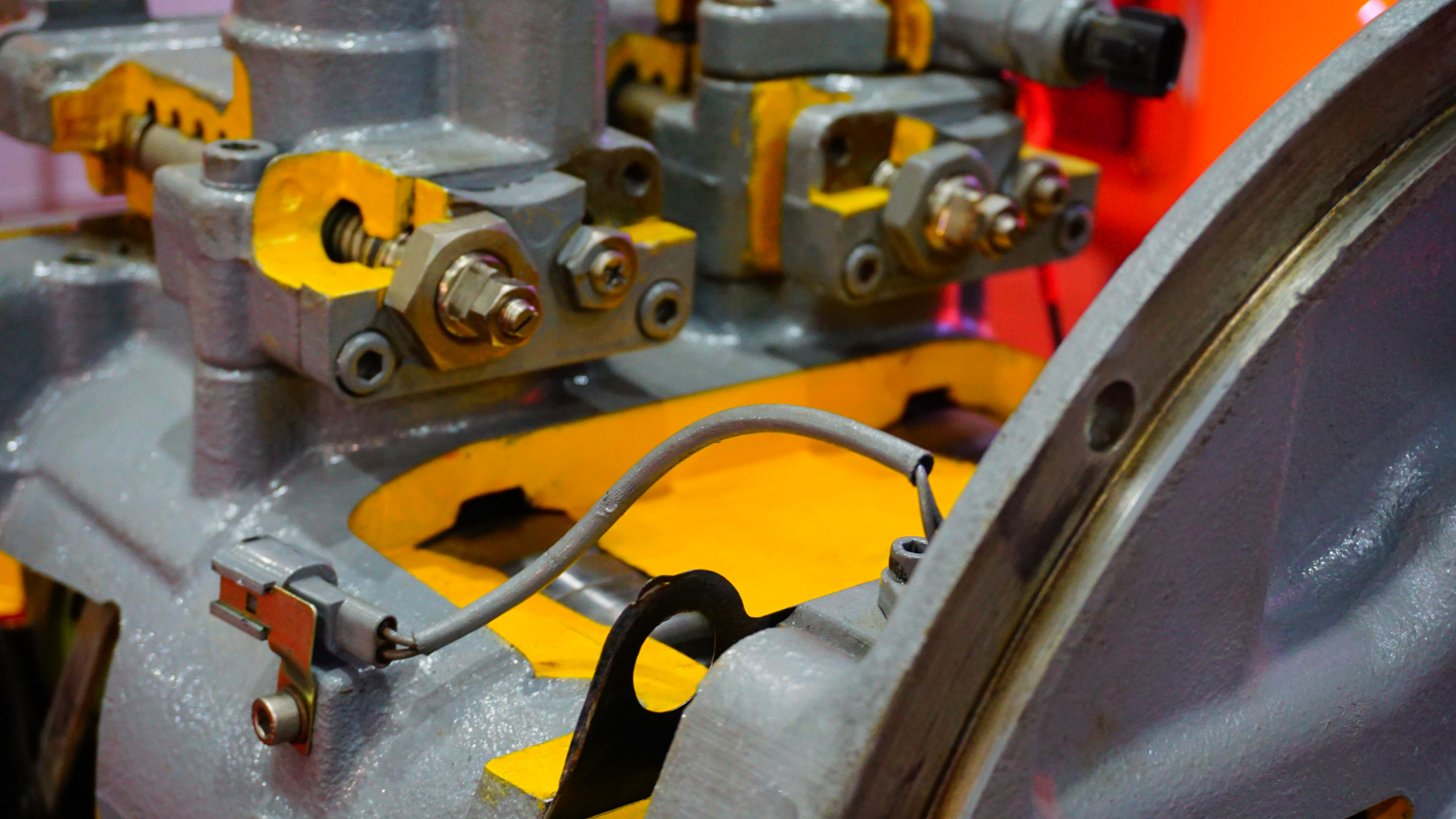 Four industrial yellow electric motors with black fan housings sitting on a wooden pallet.