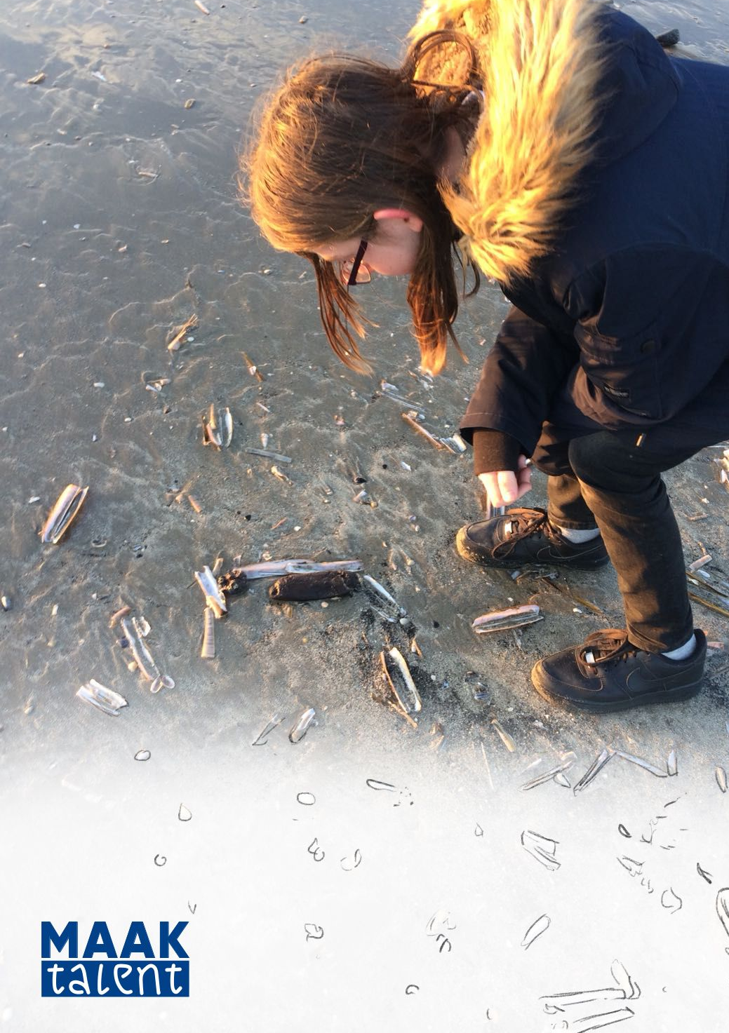 Een jongen die bekijkt de scheermes-schelpen op het strand.
