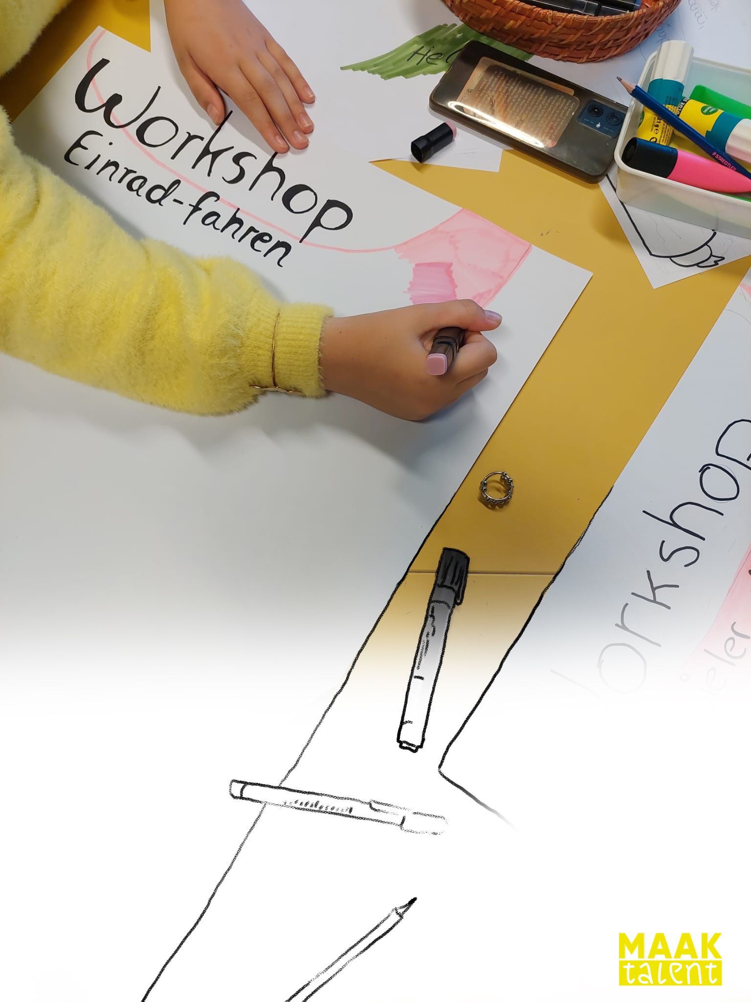 Puber kleurt met stift op de poster die zij ontworpen hebben voor duits. 